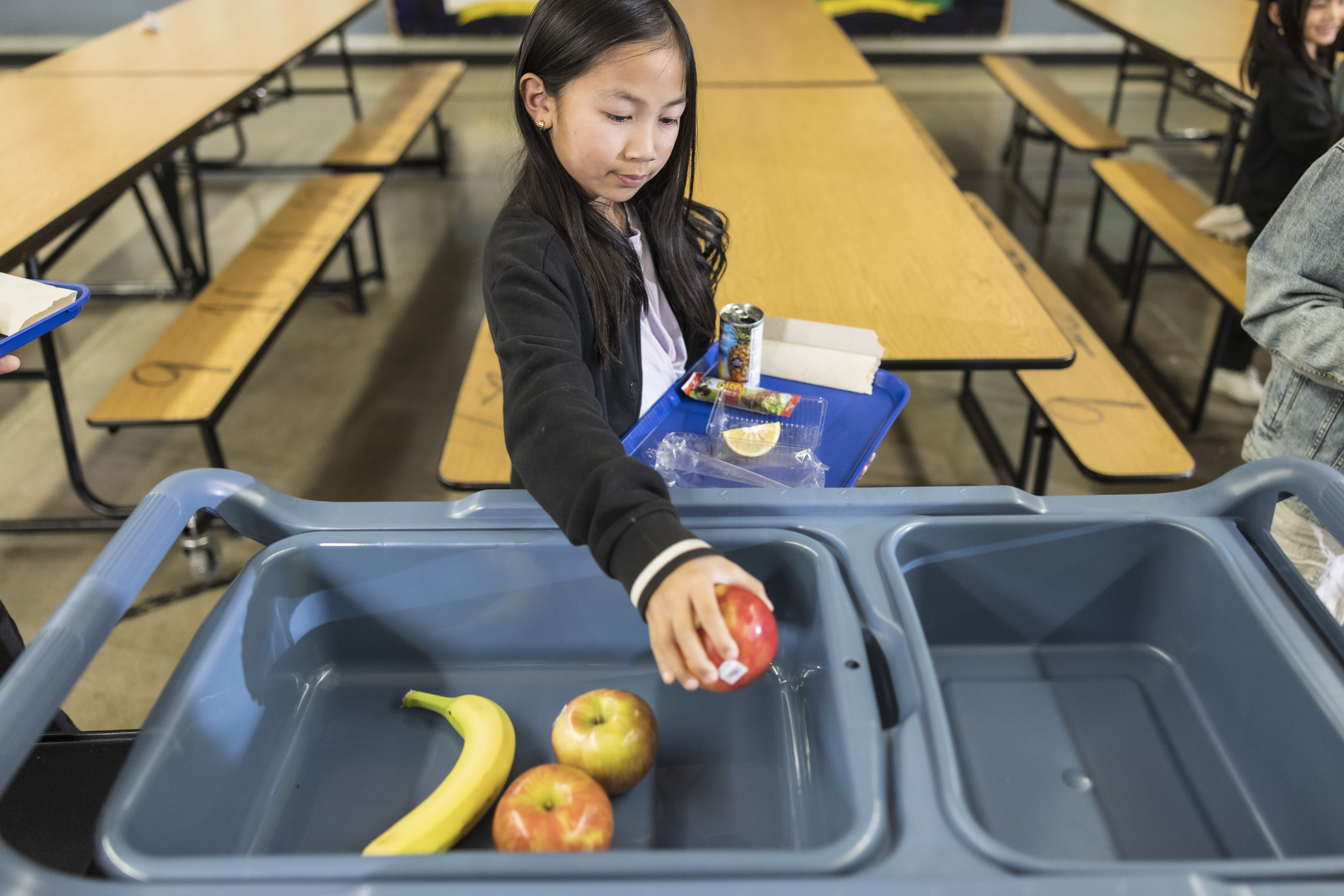 Student using Share Table in the cafeteria to donate their apple. 